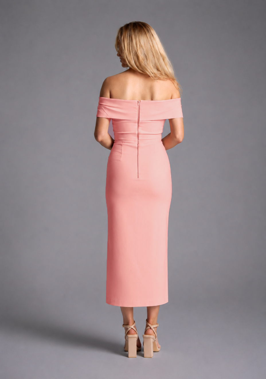 Vesper peach bardot ruched midaxi dress with off shoulder neckline and front split, back view on blonde model against grey studio background.