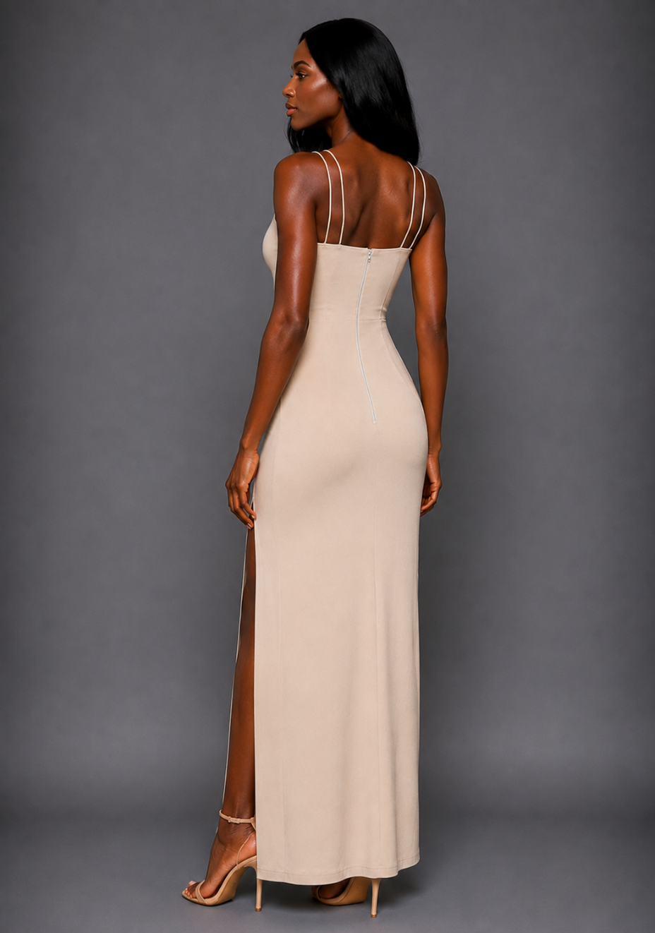 Side back image of a model wearing the VSPR Auralia High Neck Strappy Stone Maxi Dress, showcasing the slim silhouette and delicate double straps against a grey studio backdrop.