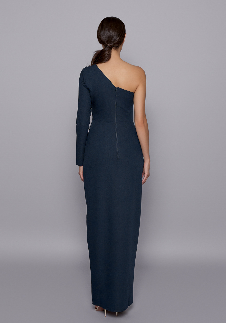 Back view of the Vesper Sophia Navy One-Sleeve Dress with a clean zip closure and contoured shape, emphasizing the elegant, sculpted fit from behind.