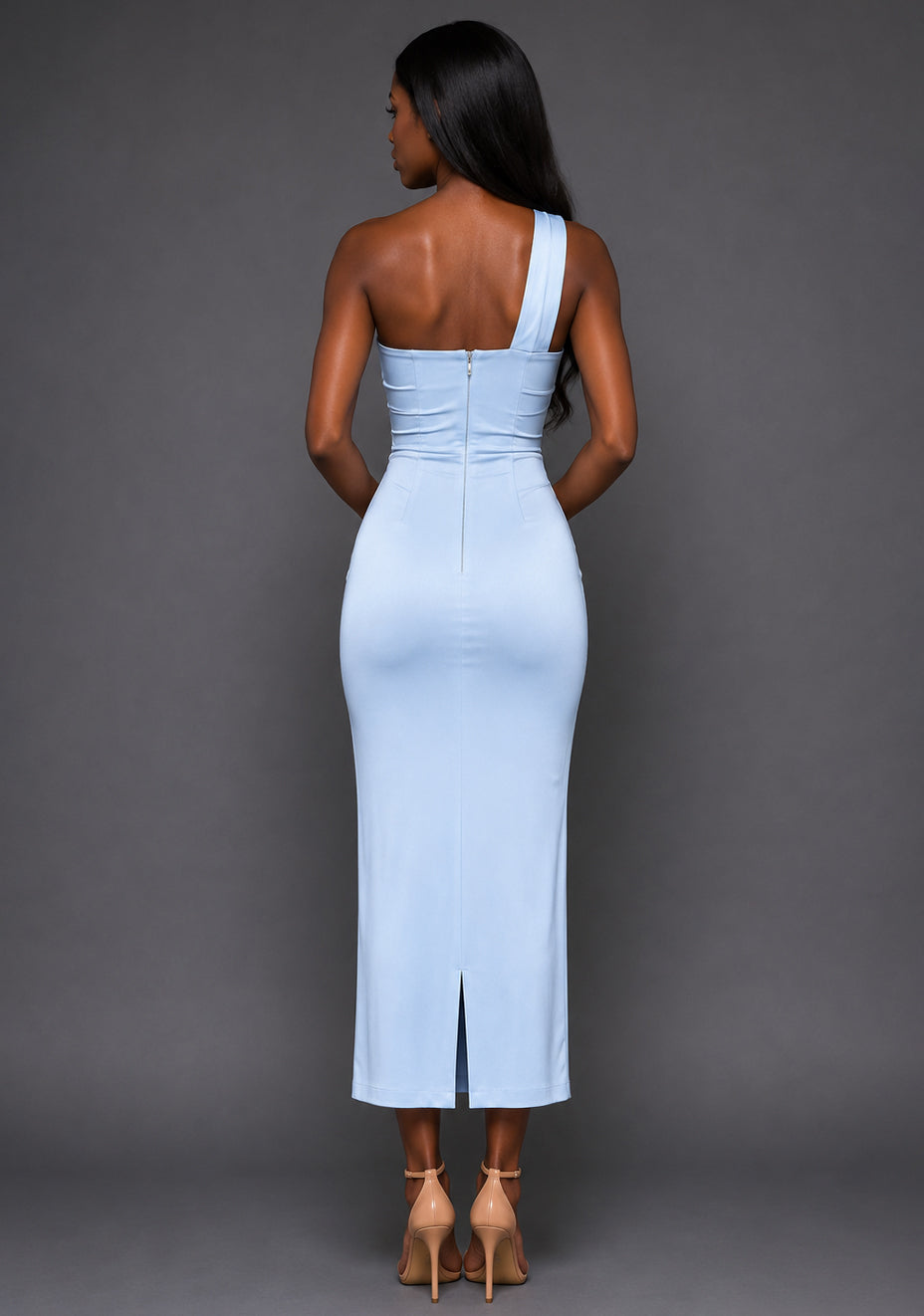 Back image of a model wearing the VSPR Tierney One Shoulder Cut Out Blue Midaxi Dress with a sleek body-contouring silhouette, smooth satin fabrication and sophisticated midaxi length, standing against a grey studio backdrop.