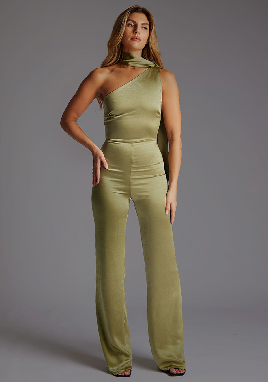 Front image of a model wearing the VSPR Juniper Halter Pine Green High-Neck Top with a sophisticated asymmetrical high-neck halter silhouette, standing against a grey studio backdrop.
