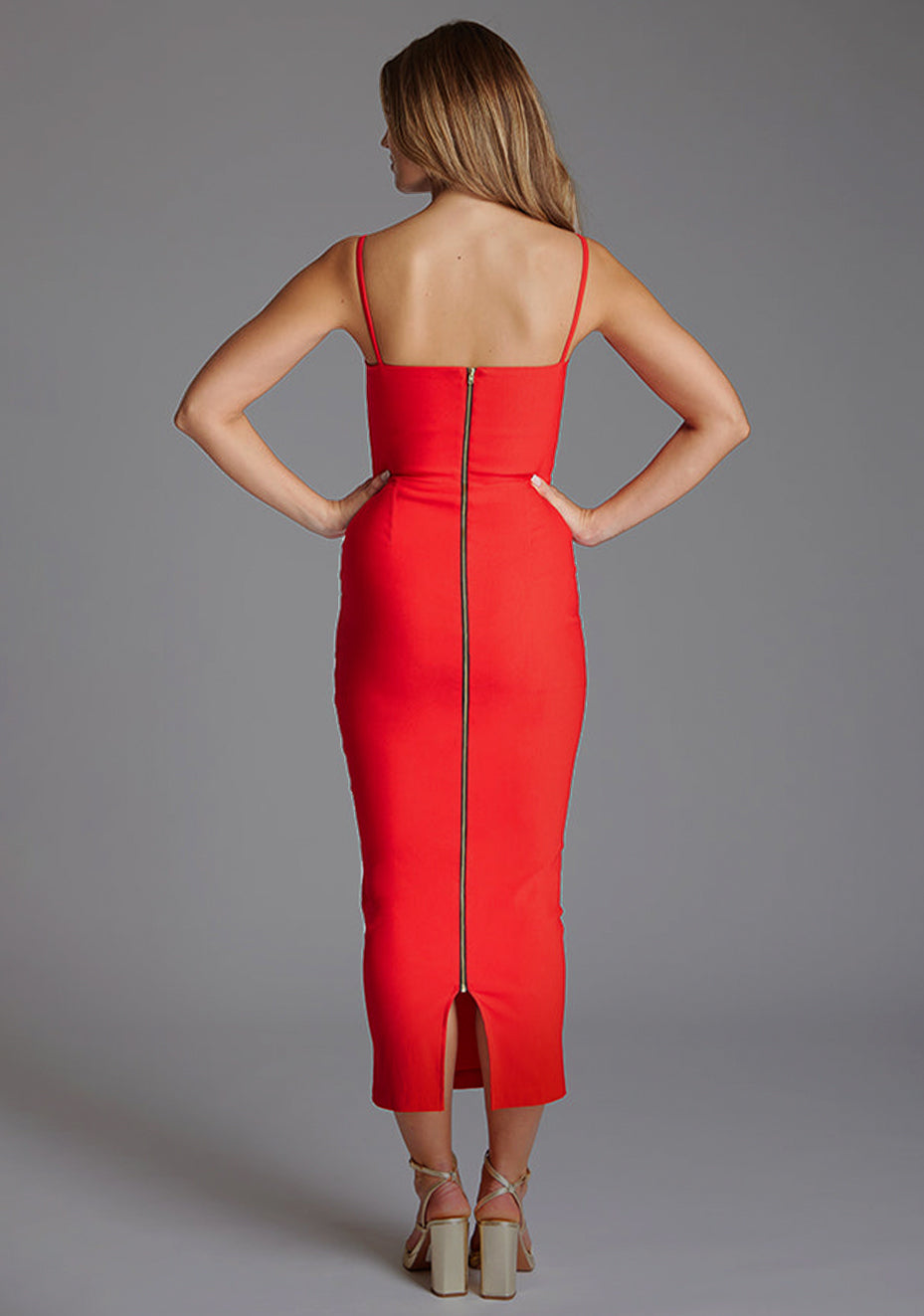Back image of the model wearing a red midaxi dress with a sweetheart neckline that accentuates your neckline beautifully, bodycon fit and centre gold back zip. The design featured is the Vesper Zoya Red Midaxi Dress.