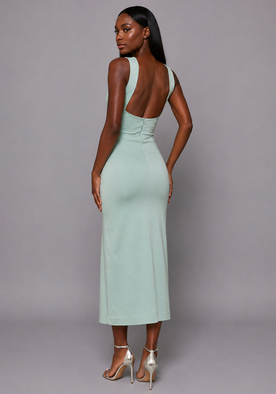 Side back image of a model wearing the VSPR Aida Cross Neck Open Back Midaxi Dress in Sage, featuring the open back design, sculpted fit, and graceful silhouette against a grey studio backdrop.