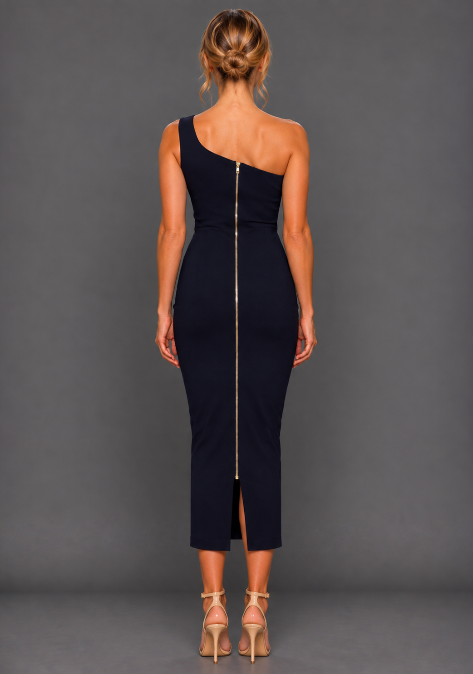 Back image of a model wearing the VSPR Eliza Navy Midaxi Dress, featuring a full-length gold zip and precision-cut body-contouring silhouette against a grey studio backdrop.