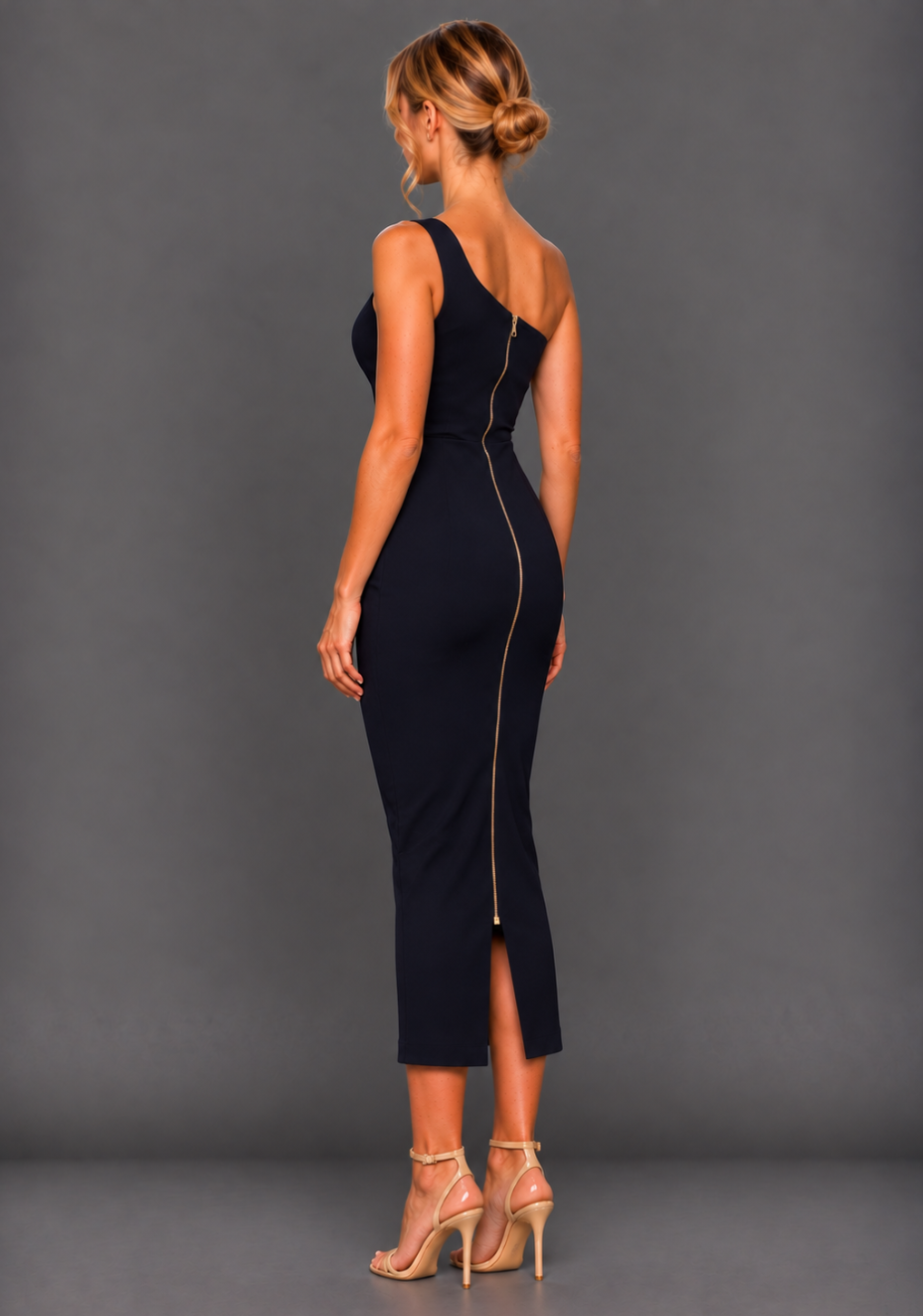 Side back image of a model wearing the VSPR Eliza Deep Navy Midaxi Dress from a side back angle, highlighting the fitted silhouette and contrasting gold hardware along the back against a grey studio backdrop.