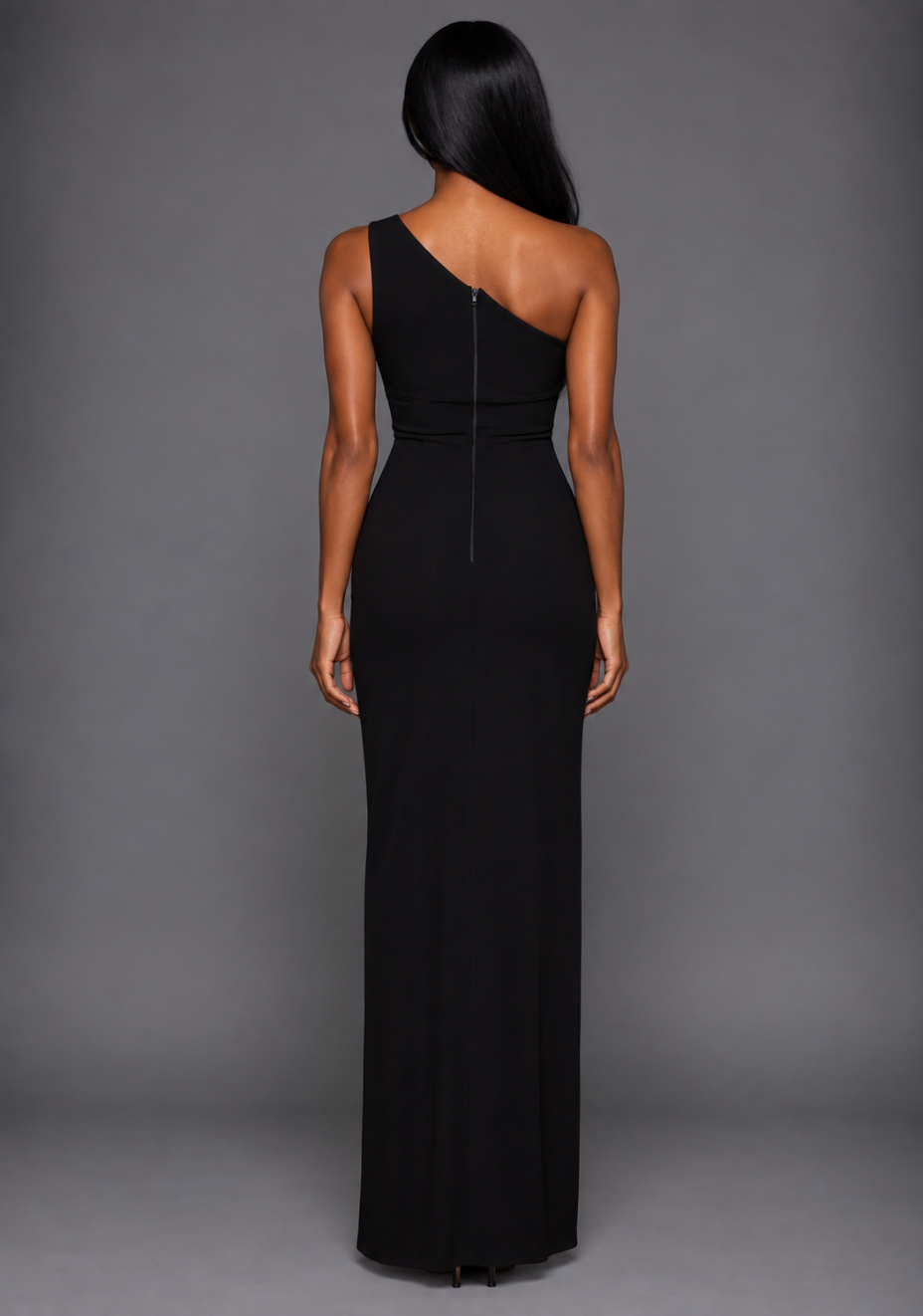 Back image of a model wearing the VSPR Fliss One Shoulder Contrast Satin Band Monochrome Maxi Dress, showcasing its sleek floor-length silhouette and smooth crepe fabric, against a grey studio backdrop