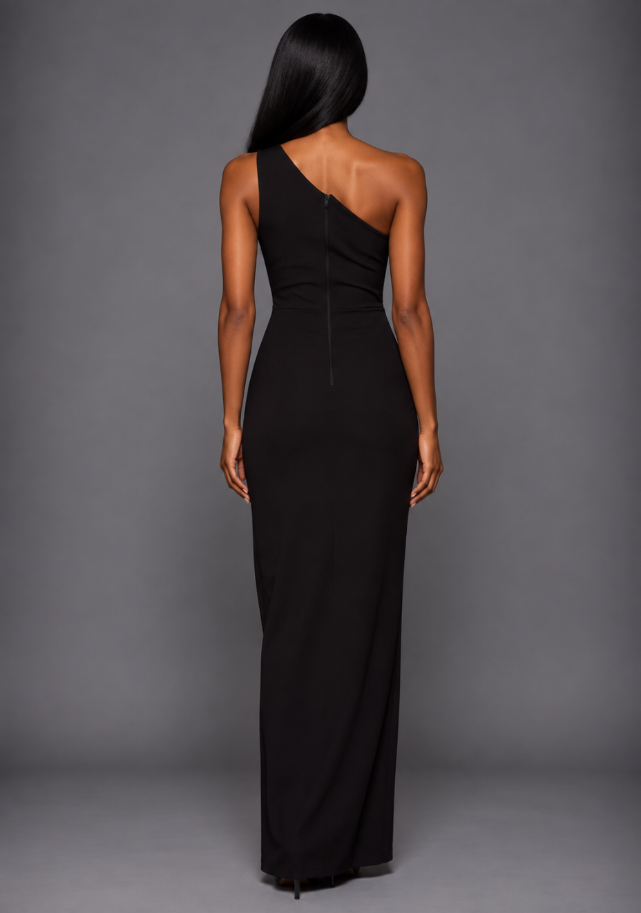 Back image of a model wearing the VSPR Fliss One Shoulder Satin Band Black Maxi Dress in a back-facing pose, showcasing the streamlined maxi-length silhouette against a grey studio backdrop.