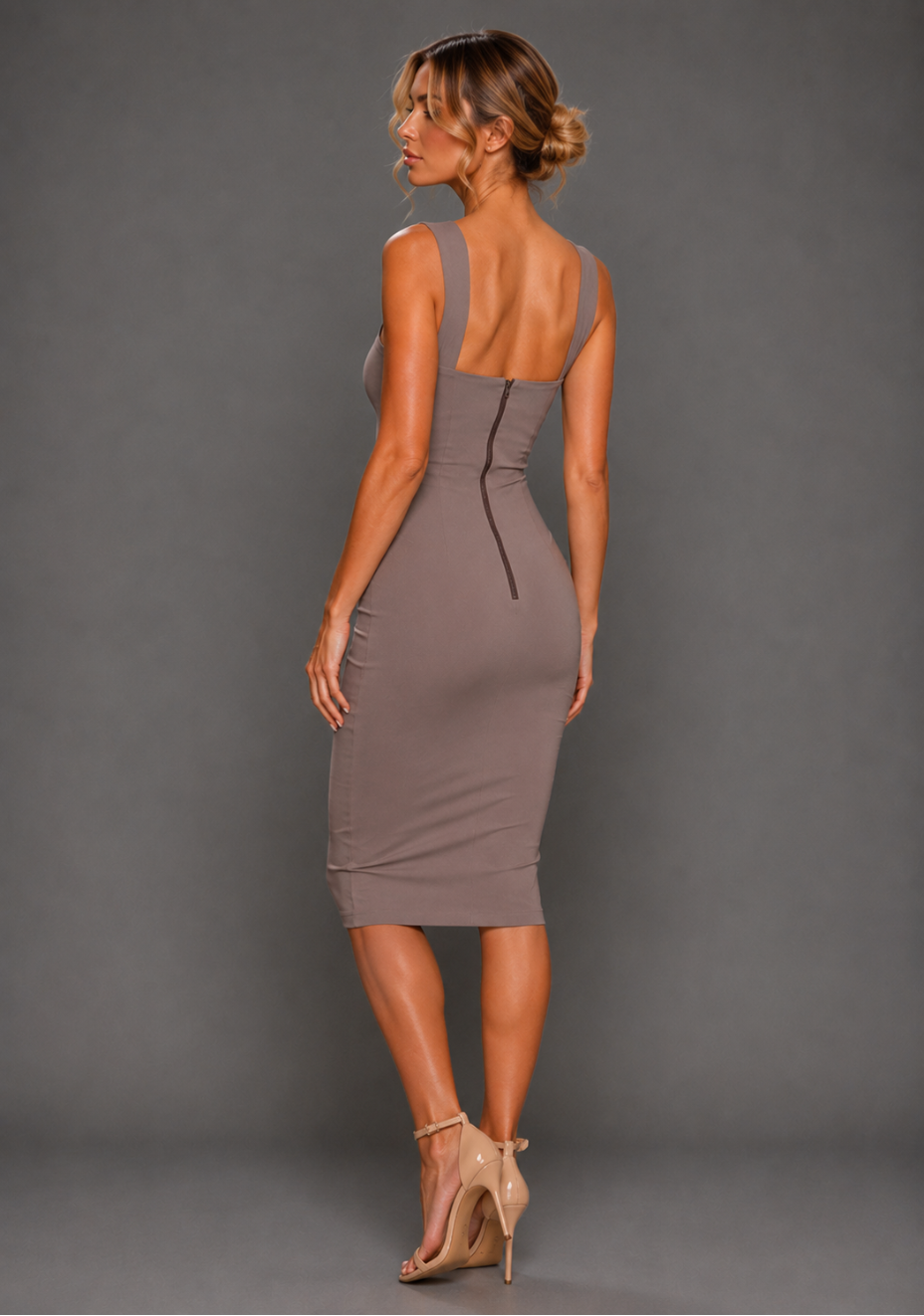 Side back model wearing the VSPR Isabelle Taupe Dress from a side back angle, showing the form-fitting stretch crepe design and elegant midi length.