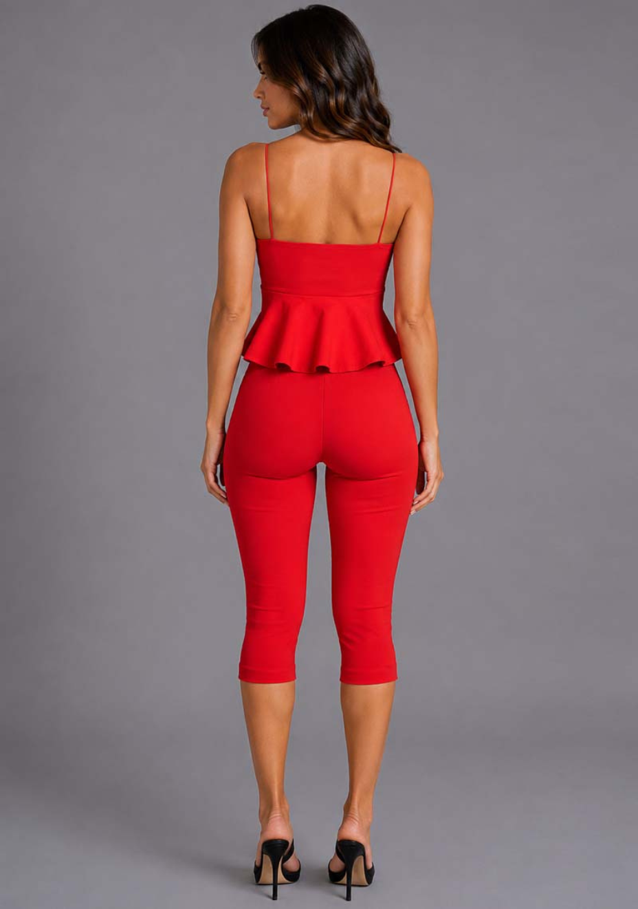 Back image of a model wearing the VSPR Jen Sweetheart Peplum Red Cami Top in red, showcasing the clean back silhouette, delicate straps, and structured peplum detail against a grey studio backdrop.