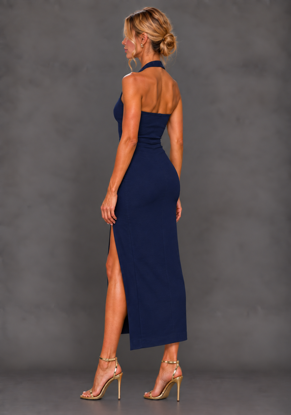 Side back image of a model wearing the VSPR Maria Thigh Split Midaxi Dress in Navy from a side back angle, showcasing the elegant fitted profile and polished occasionwear design against a grey studio backdrop.