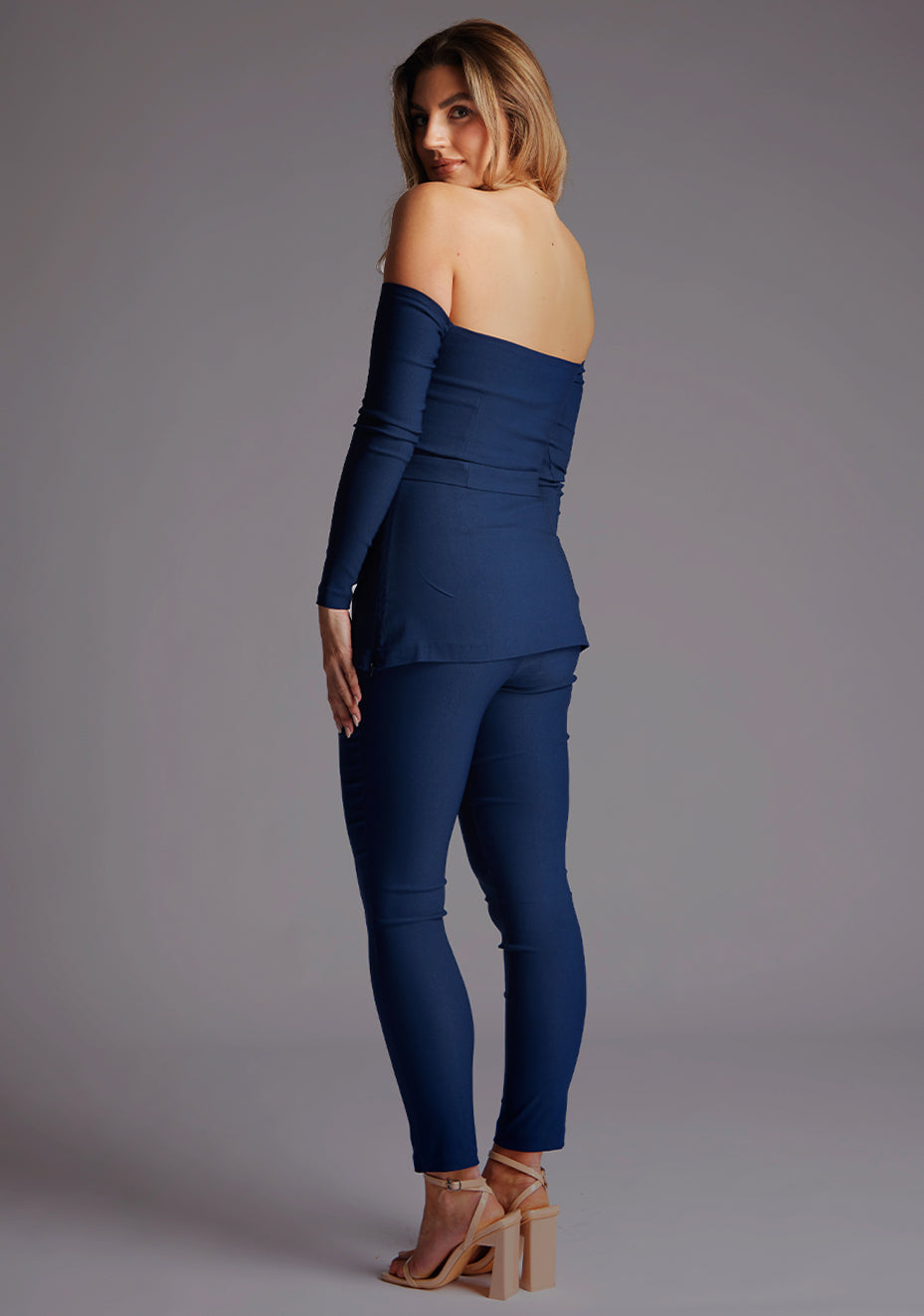 Side back image of a model wearing the Vesper Danica Slim Leg Tailored Trousers in Navy, showcasing the contoured fit and smooth back line.
