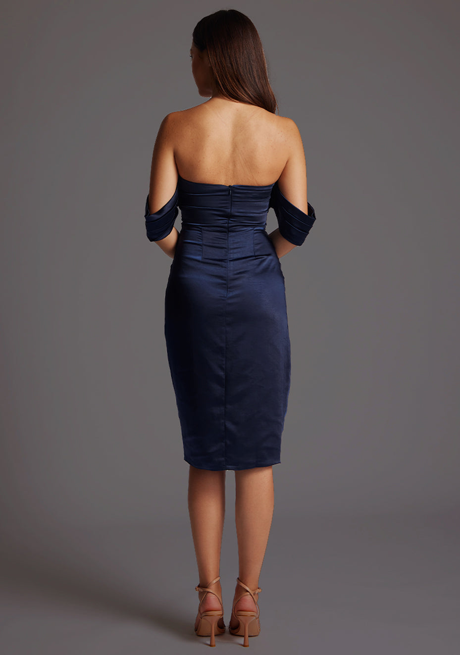 Back image of a model wearing the Vesper Fleur Bardot Neckline Satin Midi Dress in Navy, displaying the clean back design and flowing satin midi skirt.