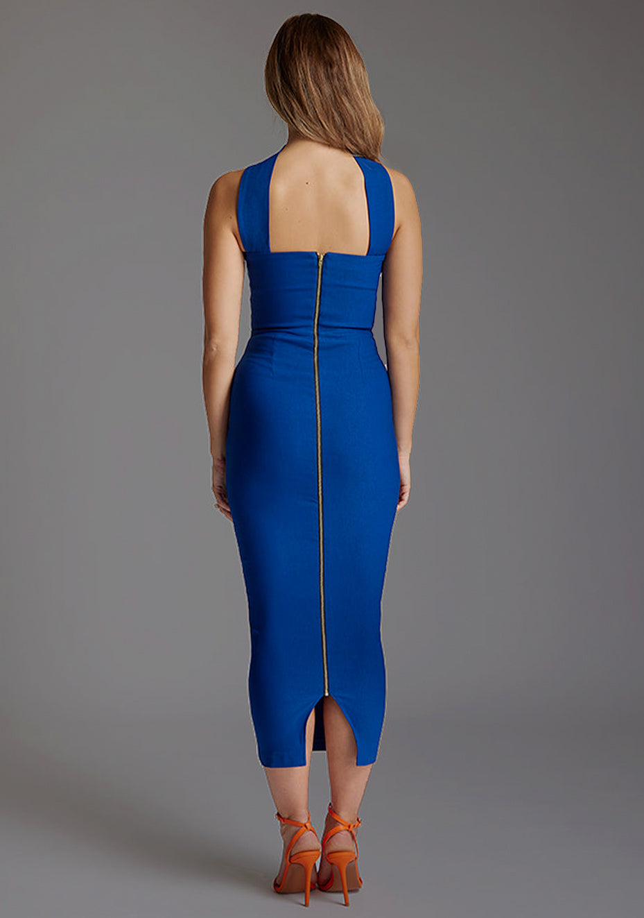 Back image of a model wearing the VSPR Frankie Strapless Bodycon Cobalt Midaxi Dress, showcasing the sleek fitted silhouette centre back gold zip and polished midaxi length.