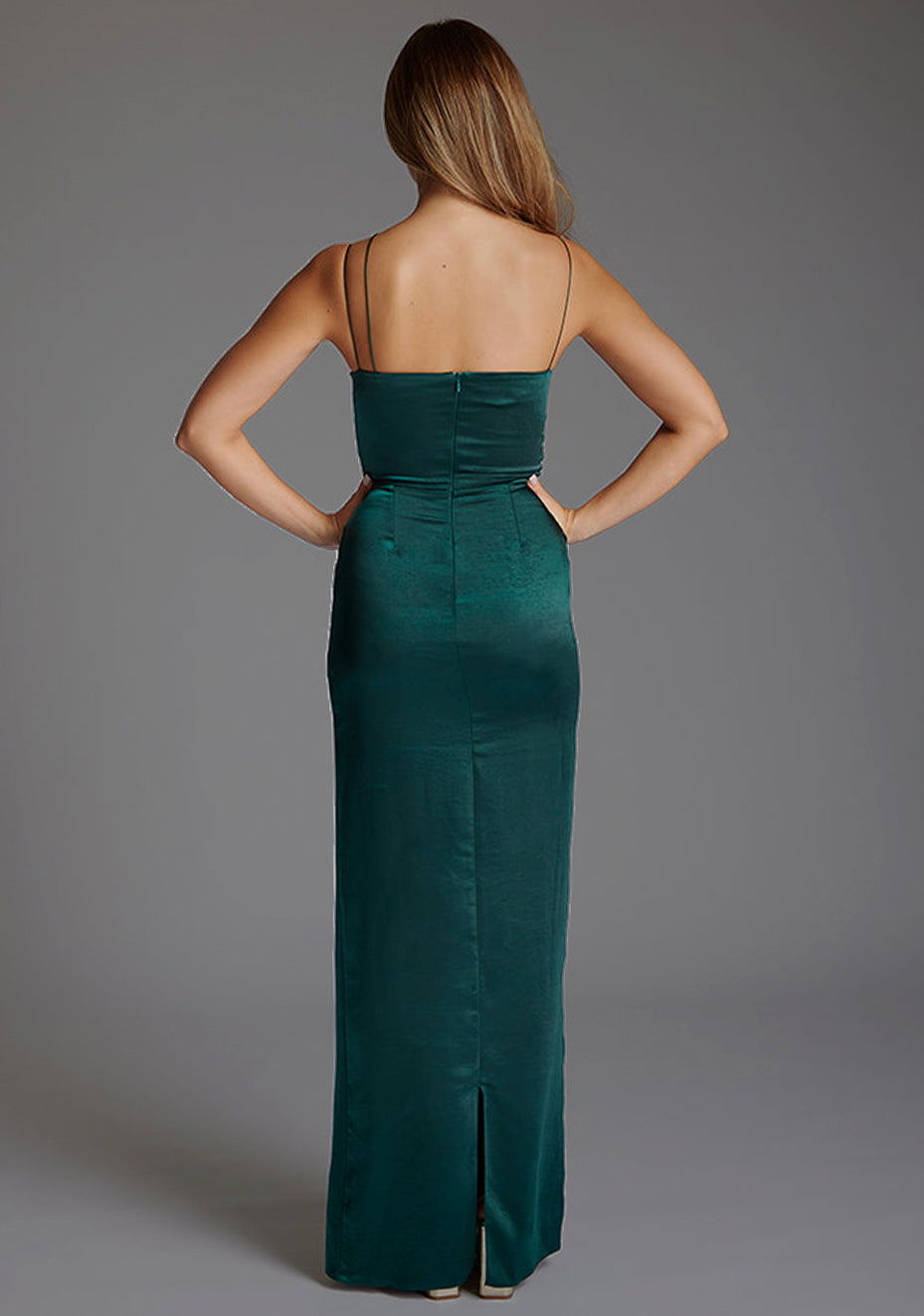 Back image of a model wearing a pine green maxi dres with a chic thin straps and featuring a tasteful ruched design and  complete with a convenient back zip. The design featured is the Vesper Lorah Satin Drape Maxi Dress in Pine Green.