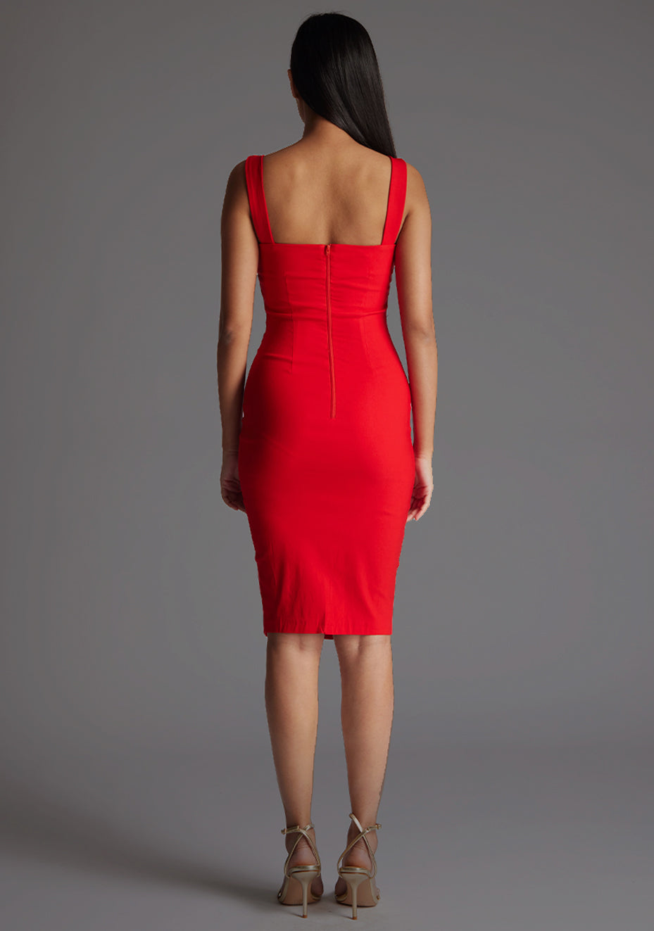 Back image of a model wearing a red maidi dress with a square neckline exudes elegance while the bodycon fit flatters your curves effortlessly and subtle yet stylish short front split. The design featured is the Vesper Praire Red Midi Dress.