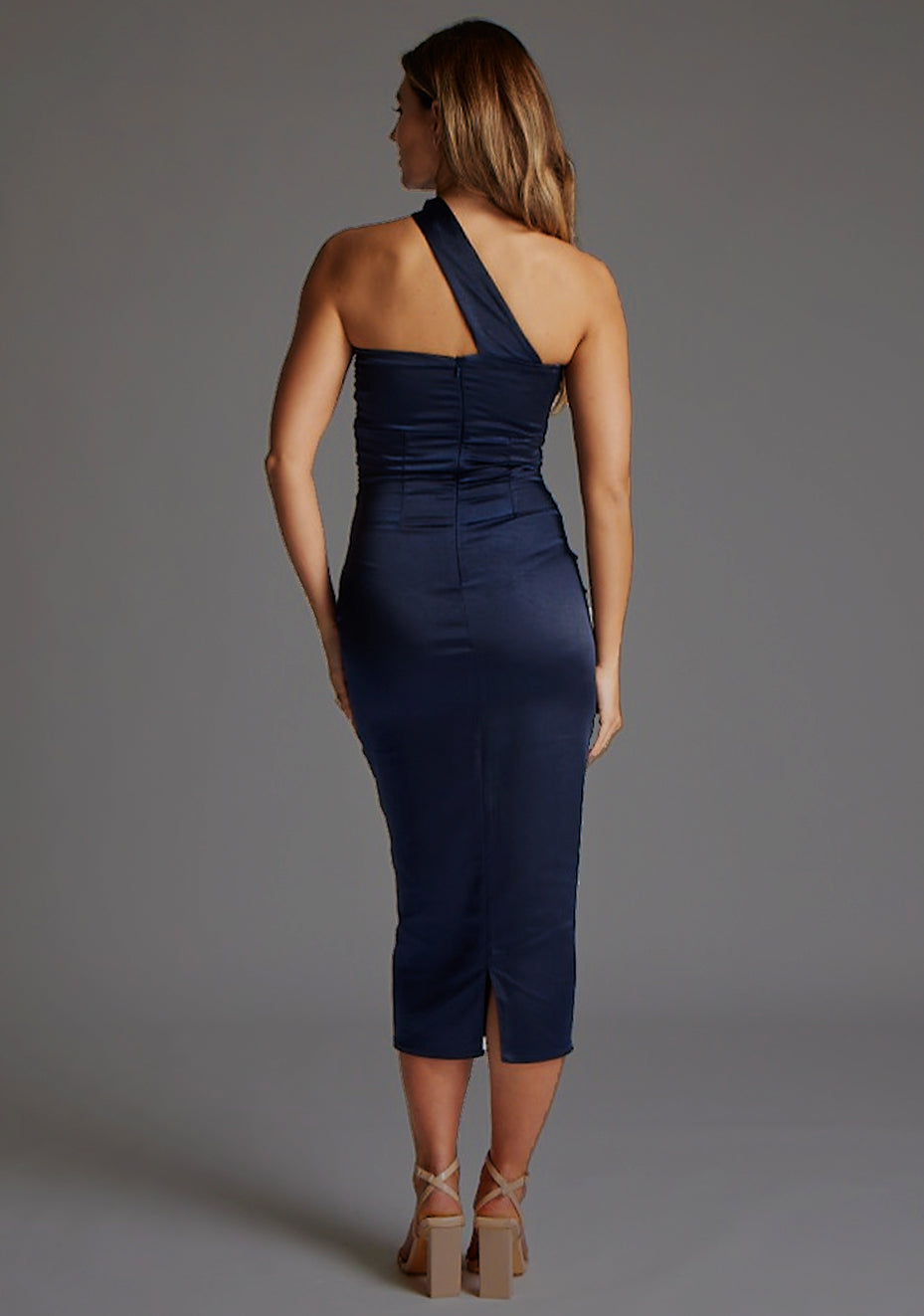 Back image of a model wearing a navy midaxi dress with a asymmetrical neckline, one-shoulder design and shirred bust with cut-out detail adds a touch of sophistication. The design featured is the Vesper Tierney Navy Midaxi Dress